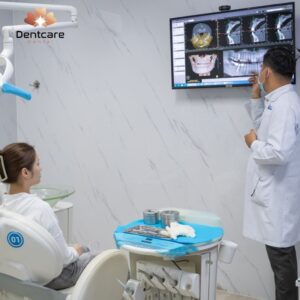 Bác sĩ chuyên khoa tại DentCare Dental đang thăm khám và tư vấn giải pháp trồng răng Implant cho khách hàng